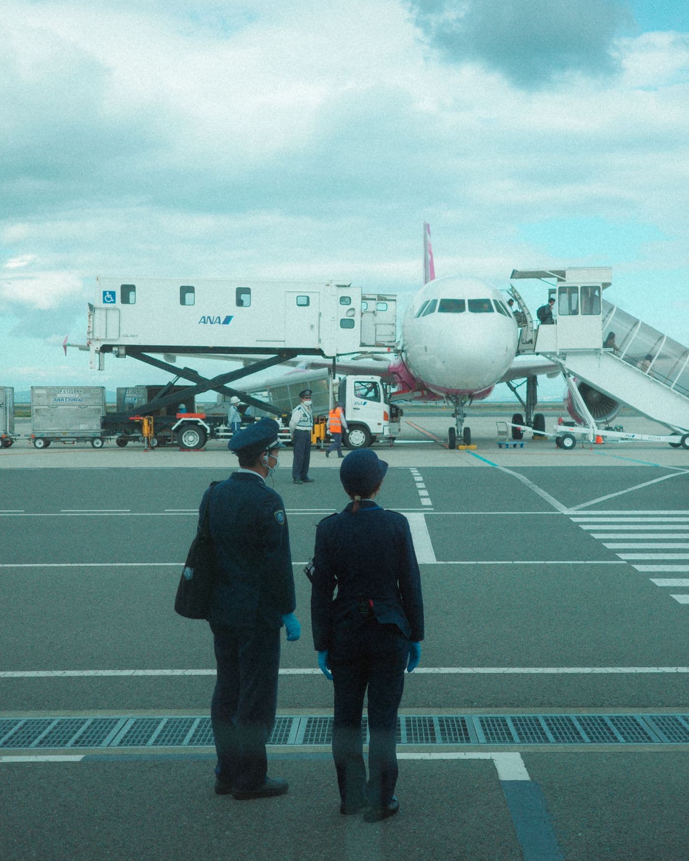 Uniformed ground staff member on the tarmac beside an aircraft