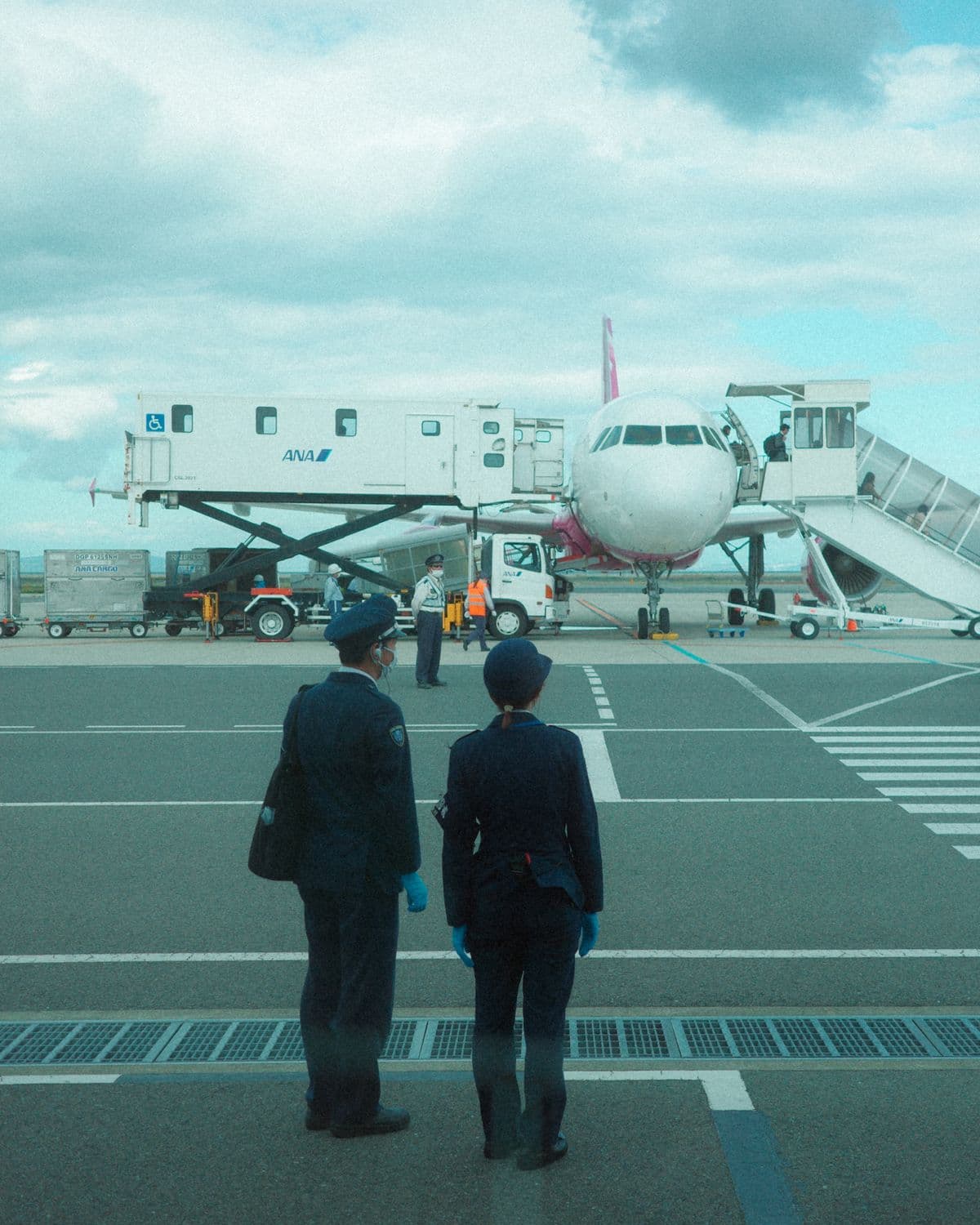 Uniformed ground staff member on the tarmac beside an aircraft