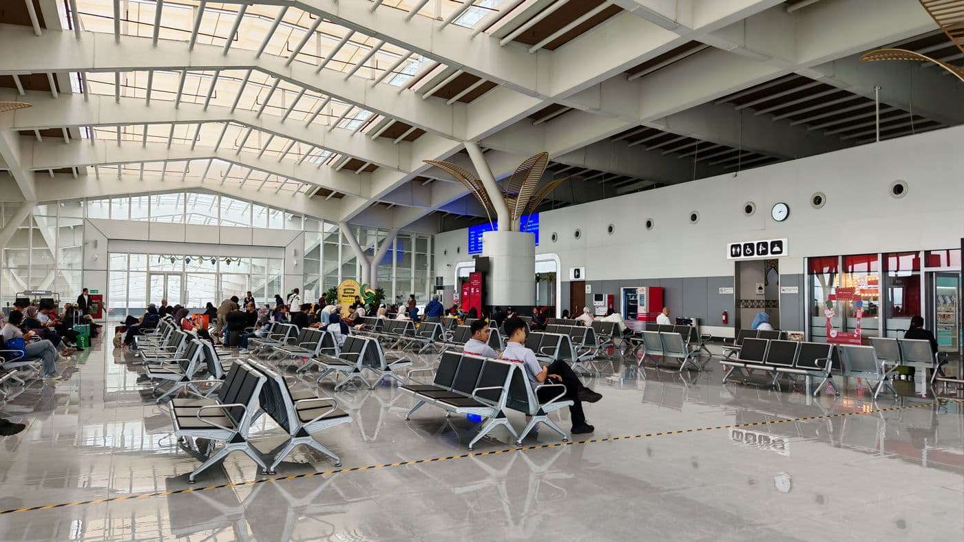 Spacious modern airport terminal lounge with seating for waiting passengers