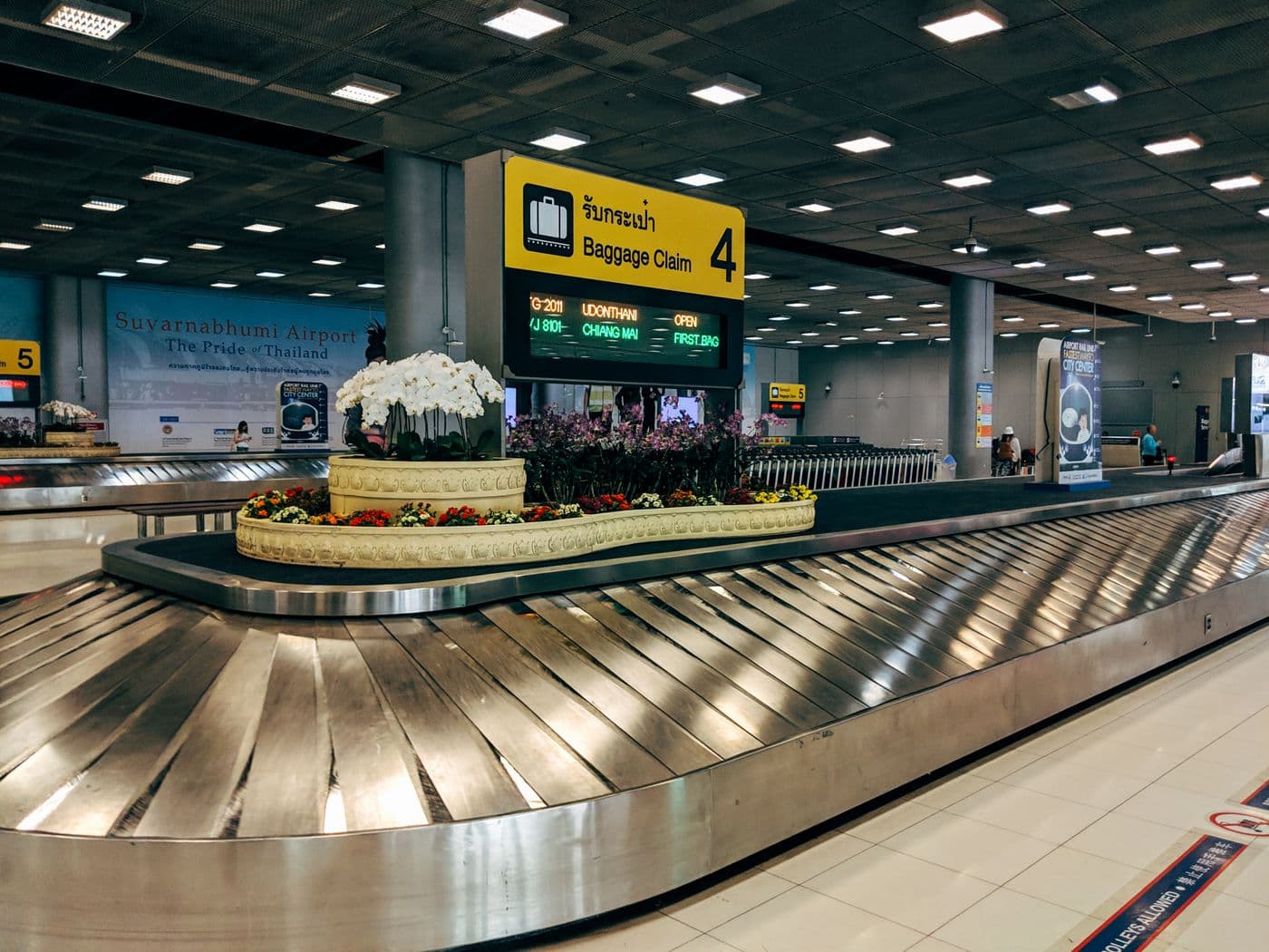 Modern baggage claim area at Suvarnabhumi Airport with luggage carousel and signage